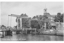 Zicht op de Korte Kerkbrug, met bakkerij Out, kapsalon van der Velde op de achtergrond de Ned. Herv. Kerk.   Datum opname: 1950
